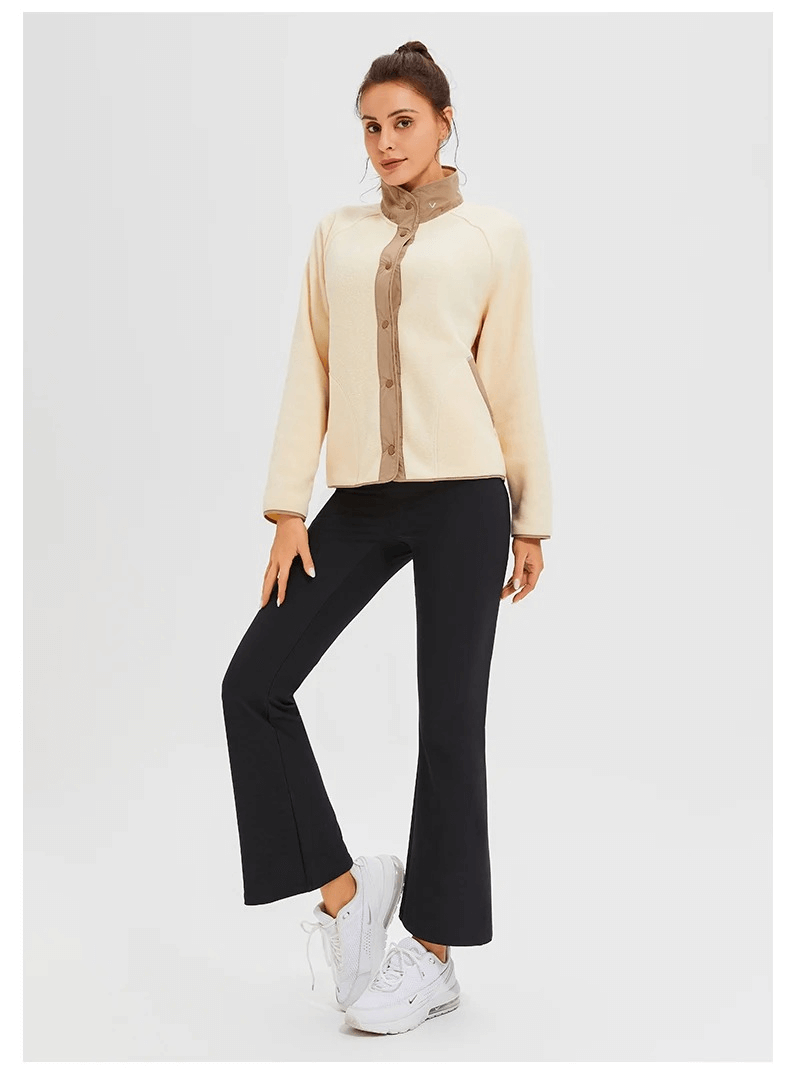 Woman wearing stylish wool sports jacket and black pants, ready for winter running with sleek mandarin collar and windproof design.